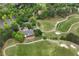Aerial view of a golf clubhouse with outdoor seating areas, set amidst lush green golf courses and mature trees at 5309 Davenport Mnr, Cumming, GA 30041