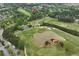 Scenic aerial view of a lush green golf course with pond and manicured fairways, offering a picturesque and serene landscape at 5309 Davenport Mnr, Cumming, GA 30041