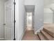 Hallway featuring neutral carpet, a view of the adjacent bathroom, and a staircase at 5309 Davenport Mnr, Cumming, GA 30041