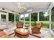Inviting sunroom showcasing views of the golf course, complemented by comfortable wicker seating at 5309 Davenport Mnr, Cumming, GA 30041