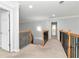 Upstairs hallway with wooden railings, carpeted floors and access to several rooms at 5309 Davenport Mnr, Cumming, GA 30041