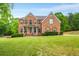 Stunning brick home featuring a manicured lawn and lush landscaping at 650 Virginia Highlands, Fayetteville, GA 30215