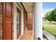 Inviting front porch with brick flooring and white columns showcasing a cozy entrance at 650 Virginia Highlands, Fayetteville, GA 30215