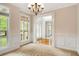 Bright living room featuring large windows, classic chandelier, and wainscoting at 650 Virginia Highlands, Fayetteville, GA 30215