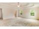 Open main bedroom with a tray ceiling, neutral carpet, bright windows and a doorway to an attached bathroom at 650 Virginia Highlands, Fayetteville, GA 30215