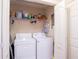 Bright laundry room featuring a washer, dryer, and shelving for organized storage at 152 Cooper Creek Dr, Dallas, GA 30157