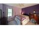 Bedroom with purple walls, a four-poster bed and natural light at 387 Cascade Sw Dr, Lilburn, GA 30047