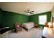 Bright bedroom with green accent wall, ceiling fan, and neutral carpet at 387 Cascade Sw Dr, Lilburn, GA 30047