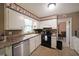 The kitchen features a stainless steel dishwasher, black oven and stove, and white cabinetry for all your cooking needs at 387 Cascade Sw Dr, Lilburn, GA 30047