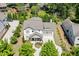 Aerial view of a charming home with well-manicured landscaping, mature trees, and a paved driveway at 500 S Hill St, Buford, GA 30518