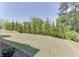Secluded backyard featuring a well-maintained lawn, established trees, and manicured landscaping at 500 S Hill St, Buford, GA 30518