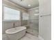 Bright bathroom showcases a soaking tub, glass-enclosed shower, and large window at 500 S Hill St, Buford, GA 30518