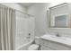 Well-lit bathroom featuring a shower-tub combo, toilet, and vanity with marble counter and decorative-framed mirror at 500 S Hill St, Buford, GA 30518