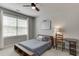 Cozy bedroom featuring a ceiling fan, a window with white curtains, and a wooden writing desk at 500 S Hill St, Buford, GA 30518