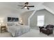 Cozy bedroom featuring vaulted ceilings, a comfortable queen-sized bed, an armchair, and natural light at 500 S Hill St, Buford, GA 30518