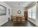 Bright dining room with hardwood floors, a white brick accent wall, and a rustic dining table with seating for eight at 500 S Hill St, Buford, GA 30518