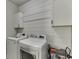 Efficient laundry room with white cabinets, a rod for hanging clothes, and modern washing machine and dryer units at 500 S Hill St, Buford, GA 30518