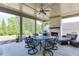 Relaxing covered patio area with a brick fireplace, ceiling fan, and comfortable seating and dining at 500 S Hill St, Buford, GA 30518