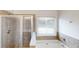 Bathroom with tiled shower and soaking tub by the window at 881 Upland Ives Dr, Sugar Hill, GA 30518