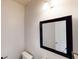 Modern powder room with a pedestal sink, stylish mirror, and neutral color scheme at 881 Upland Ives Dr, Sugar Hill, GA 30518