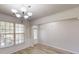 Bright dining room features elegant wainscoting, wood floors, large windows, and a glass door at 881 Upland Ives Dr, Sugar Hill, GA 30518