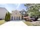 Charming two-story home featuring a brick facade, attached two-car garage, and beautifully landscaped front yard at 881 Upland Ives Dr, Sugar Hill, GA 30518