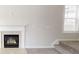 Cozy living room featuring a fireplace, plush carpet, and a large window offering natural light at 881 Upland Ives Dr, Sugar Hill, GA 30518