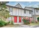 Charming townhome featuring a stone facade, red door, and blossoming shrubbery at 1151 Rankin St # 2C, Stone Mountain, GA 30083