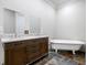 Bright bathroom featuring double sinks, granite countertops, a vanity, and a soaking tub at 2909 Jones Mill Rd, Atlanta, GA 30360