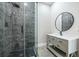 Modern bathroom featuring a glass-enclosed shower with dark tile and a stylish vanity with a round mirror at 2909 Jones Mill Rd, Atlanta, GA 30360