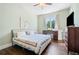 Bright bedroom with hardwood floors, a ceiling fan, and a large window overlooking the landscaped yard at 2909 Jones Mill Rd, Atlanta, GA 30360