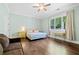 Bright bedroom with hardwood floors, a ceiling fan, and a large window overlooking the landscaped yard at 2909 Jones Mill Rd, Atlanta, GA 30360