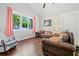 Bright living room with hardwood floors, neutral walls, large windows, and comfortable leather sofas at 2909 Jones Mill Rd, Atlanta, GA 30360