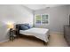 Neutral bedroom with a large window, side tables, and a comfortable bed at 4337 Orchard Park Ct, Stone Mountain, GA 30083