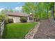 Well-maintained backyard featuring lush lawn, mature trees, and rock feature at 7045 W Mountain Xing, Cumming, GA 30041