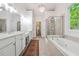 Luxurious bathroom featuring a soaking tub, walk-in shower, and double vanity sinks at 7045 W Mountain Xing, Cumming, GA 30041