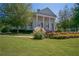 Clubhouse exterior with white columns and landscaped gardens on a sunny day at 7045 W Mountain Xing, Cumming, GA 30041