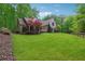 Expansive front yard leading to a light brick home with lush, mature trees surrounding the property at 7045 W Mountain Xing, Cumming, GA 30041