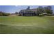 Exterior view of golf course with lush green grass and a clubhouse in the background at 7045 W Mountain Xing, Cumming, GA 30041