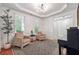 Sitting room featuring a piano, two chairs, detailed trim and an elegant tray ceiling at 7045 W Mountain Xing, Cumming, GA 30041