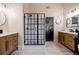 Modern bathroom featuring double vanities, patterned floors, and a glass shower at 7155 Hartsfield Pl, Suwanee, GA 30024