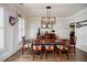 Elegant dining room with hardwood floors, wainscoting, and a modern chandelier at 7155 Hartsfield Pl, Suwanee, GA 30024