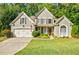 Charming two-story home with a well-manicured lawn, inviting entrance, and attached two-car garage at 7155 Hartsfield Pl, Suwanee, GA 30024