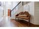 Inviting foyer with hardwood floors, staircase with black railings, and a charming wooden bench at 7155 Hartsfield Pl, Suwanee, GA 30024