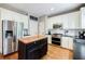 Modern kitchen with stainless steel appliances, white cabinets, and a butcher block island at 7155 Hartsfield Pl, Suwanee, GA 30024