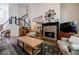 Inviting living room with a stone fireplace, comfortable seating, and a view of the staircase at 7155 Hartsfield Pl, Suwanee, GA 30024