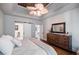Spacious main bedroom featuring wood floors, modern dresser, and fan lighting at 7155 Hartsfield Pl, Suwanee, GA 30024