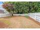 Large, level backyard featuring a charming white picket fence and mature trees at 905 Downyshire Dr, Lawrenceville, GA 30044