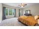 A spacious bedroom features plush carpeting, natural light, and a ceiling fan at 168 Constitution Blvd # 12, Lawrenceville, GA 30046