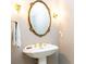 Elegant bathroom featuring a pedestal sink with a gold-framed mirror and sconces at 211 Colonial Homes Nw Dr # 2508, Atlanta, GA 30309